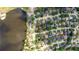 Aerial view of a cozy home surrounded by lush greenery, complemented by a beautiful lake and well-maintained neighborhood at 397 Quail Hill Dr, Debary, FL 32713