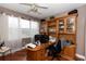 Comfortable home office with built-in shelves, desk, ceiling fan, and hardwood floors at 397 Quail Hill Dr, Debary, FL 32713