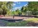 Community playground featuring swings, a play structure with a slide, and a spring rider with cushioned ground covering at 397 Quail Hill Dr, Debary, FL 32713