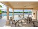 A covered outdoor seating area featuring tables and chairs overlooks a pool and a beautiful lake at 397 Quail Hill Dr, Debary, FL 32713