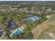 Aerial view of four well maintained tennis courts and a pool with lounge seating surrounded by beautiful landscaping at 397 Quail Hill Dr, Debary, FL 32713
