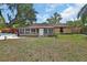 Backyard view of the sunroom, inground pool, mature trees, and wood fence at 416 N Blue Lake Ter, Deland, FL 32724