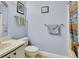 Well-lit bathroom featuring a toilet, sink, and shower with a bright shower curtain at 416 N Blue Lake Ter, Deland, FL 32724