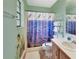 Cozy bathroom with colorful shower curtain, shower and classic tile flooring at 416 N Blue Lake Ter, Deland, FL 32724