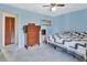 Bright blue bedroom with a large window, carpeted flooring, and classic dresser at 416 N Blue Lake Ter, Deland, FL 32724