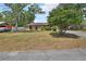 A charming home featuring a well-manicured lawn, mature trees, and a classic car on the side at 416 N Blue Lake Ter, Deland, FL 32724