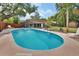 Large inground pool surrounded by patio and landscaping with mature trees and wood fence at 416 N Blue Lake Ter, Deland, FL 32724