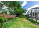 Landscaped backyard with a screened patio area, brick wall, mature trees and healthy green lawn at 470 Foxhill Dr, Debary, FL 32713