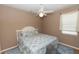 Cozy bedroom with a ceiling fan, window, and a bed with patterned blue and white linens at 470 Foxhill Dr, Debary, FL 32713