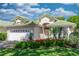 Charming home showcasing lush landscaping, a green tile roof, and a pristine white two-car garage at 470 Foxhill Dr, Debary, FL 32713