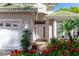 Inviting front entrance with a decorative white door, lush red flowers, and a well-maintained two-car garage at 470 Foxhill Dr, Debary, FL 32713