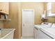 Functional laundry room with washer, dryer, utility sink, and storage shelves at 470 Foxhill Dr, Debary, FL 32713