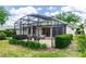 Exterior view of a screened patio with comfortable outdoor seating surrounded by green landscaping at 470 Foxhill Dr, Debary, FL 32713