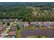 An aerial view shows the home, neighboring houses with pools, and the pond with lush tree coverage in the surrounding neighborhood at 5463 Carmody Lake Dr, Port Orange, FL 32128