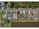 An aerial view displays the property and its surroundings, highlighting mature trees, lush landscaping, and pond access in the neighborhood at 5463 Carmody Lake Dr, Port Orange, FL 32128