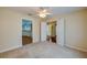 Neutral carpeted bedroom with ceiling fan and multiple entryways to other areas of the home at 5463 Carmody Lake Dr, Port Orange, FL 32128