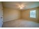 Bright primary bedroom featuring a ceiling fan and natural light from the window at 5463 Carmody Lake Dr, Port Orange, FL 32128