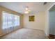 Cozy bedroom with a ceiling fan, neutral carpet, window and white door at 5463 Carmody Lake Dr, Port Orange, FL 32128