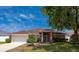 Charming single-story home with brick accents, a well-maintained lawn, and an attached garage at 5463 Carmody Lake Dr, Port Orange, FL 32128