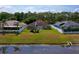 A single-story home featuring a well-manicured lawn, fenced yard, and partial view of a serene pond, nestled between mature trees at 5463 Carmody Lake Dr, Port Orange, FL 32128