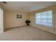Bright living room with a large window, neutral carpet, and a plant for added greenery at 5463 Carmody Lake Dr, Port Orange, FL 32128
