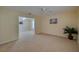 Spacious living room with a view into the next room, neutral carpet, and a large window at 5463 Carmody Lake Dr, Port Orange, FL 32128