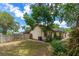 A home's backyard offers a blend of green space and natural growth, framed by a classic wooden fence at 5788 Devon St, Port Orange, FL 32127