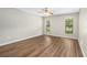 Neutral bedroom featuring wood-look floors, a ceiling fan, and bright windows at 5788 Devon St, Port Orange, FL 32127