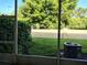 Green backyard view from a screen door, showing the well-maintained lawn and trees for a peaceful outdoor enjoyment at 6043 Strada Isle Way, Orlando, FL 32835