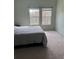 A simple bedroom with soft carpet, neutral walls, and natural light from two windows at 6043 Strada Isle Way, Orlando, FL 32835