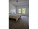 Carpeted bedroom featuring neutral walls and a large window overlooking greenery at 6043 Strada Isle Way, Orlando, FL 32835
