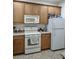 Kitchen featuring wooden cabinets and white appliances at 6043 Strada Isle Way, Orlando, FL 32835