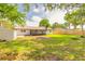 Expansive backyard features a well-maintained lawn, storage shed, new fence, and large, covered patio at 612 Moonpenny Cir, Port Orange, FL 32127