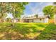 Spacious backyard with a new fence, mature trees, green grass, and screened patio with a storage shed at 612 Moonpenny Cir, Port Orange, FL 32127