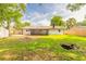 Large backyard with mature trees, a storage shed, and screened in patio, with lush green grass and new fence at 612 Moonpenny Cir, Port Orange, FL 32127