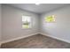 Bright bedroom with wood-look tile flooring and natural light from two windows at 612 Moonpenny Cir, Port Orange, FL 32127