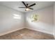 Cozy bedroom with wood-look tile floors, neutral walls, ceiling fan, and natural light at 612 Moonpenny Cir, Port Orange, FL 32127