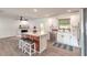 Bright kitchen features stainless appliances, an island with bar stool seating, and stylish wood-look flooring at 612 Moonpenny Cir, Port Orange, FL 32127