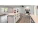 Open kitchen with an island with dark hardware, light countertops, and wood-look floors for seamless living at 612 Moonpenny Cir, Port Orange, FL 32127