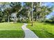 Serene backyard featuring lush greenery and a charming walkway at 6317 Palmas Bay Cir, Port Orange, FL 32127