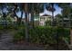 Lush backyard with a two-story home featuring a gazebo, privacy fence, and mature palm trees at 6317 Palmas Bay Cir, Port Orange, FL 32127