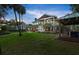 Spacious backyard showcasing a well-manicured lawn, outdoor kitchen, and a two-story home with ample space at 6317 Palmas Bay Cir, Port Orange, FL 32127