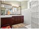 Bathroom with a double vanity, dark wood cabinetry, and glass block window, offering plenty of counter space at 6317 Palmas Bay Cir, Port Orange, FL 32127