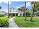 Charming two-story home with a quaint walkway, lush landscaping, and an inviting outdoor kitchen at 6317 Palmas Bay Cir, Port Orange, FL 32127