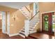 Elegant foyer featuring a staircase with wood steps and a glass-paneled front door at 6317 Palmas Bay Cir, Port Orange, FL 32127