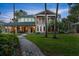 Stunning two-story home with a green metal roof, manicured lawn, and a charming walkway leading to the entrance at 6317 Palmas Bay Cir, Port Orange, FL 32127