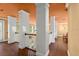 Bright hallway featuring wood floors, white columns, and an orange ceiling, offering a spacious and elegant transition between rooms at 6317 Palmas Bay Cir, Port Orange, FL 32127