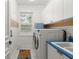 Bright laundry room equipped with white cabinets, a sink with blue trim, and a side-by-side washer and dryer at 6317 Palmas Bay Cir, Port Orange, FL 32127