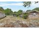 View of the backyard featuring brick accents, a covered porch, and mature trees at 636 W Mathis St, Deland, FL 32720