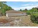 View of backyard with a home featuring light yellow siding and surrounded by mature trees at 636 W Mathis St, Deland, FL 32720